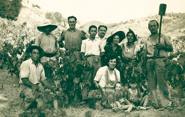 Fotografia familiar en blanco y negro donde aparecen adultos y niños posando delante de los viñedos
